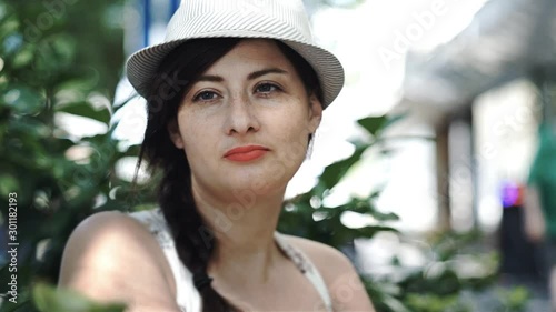 Beautiful woman is thinking and looking far away sitting in a Cafe, with street background in hd resolution photo