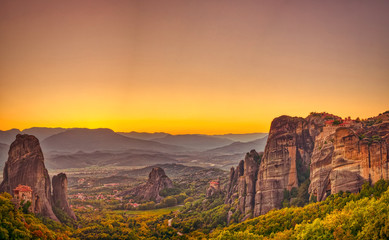 Fototapete Honigfarbe Landschaft mit Klöstern und Felsformationen in Meteora, Griechenland. während des Sonnenuntergangs.  © ververidis