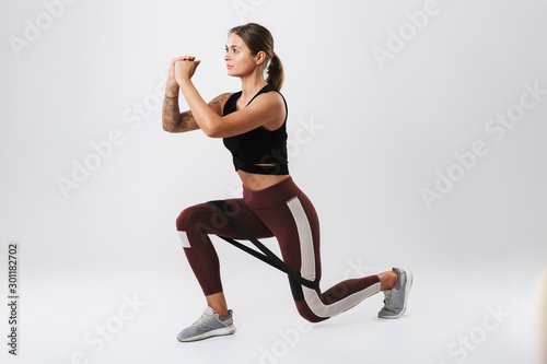 Image of concentrated woman doing workout with expander equipment