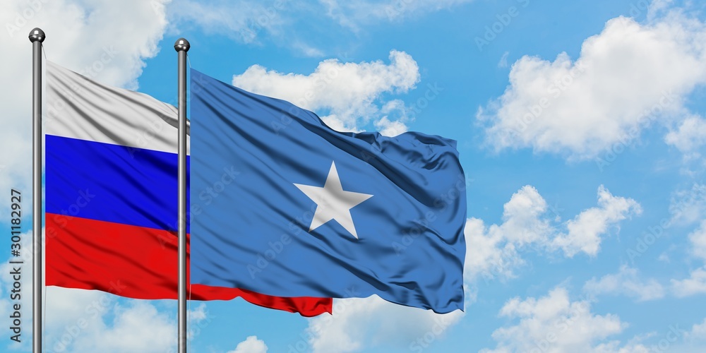 Russia and Somalia flag waving in the wind against white cloudy blue sky together. Diplomacy concept, international relations.