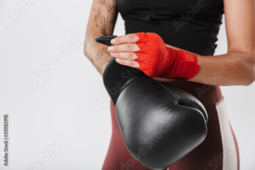 Cropped image of active woman training in boxing gloves and hand wraps