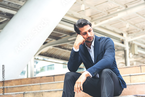 Portrait of young, depressed man in pain and suffering from work.