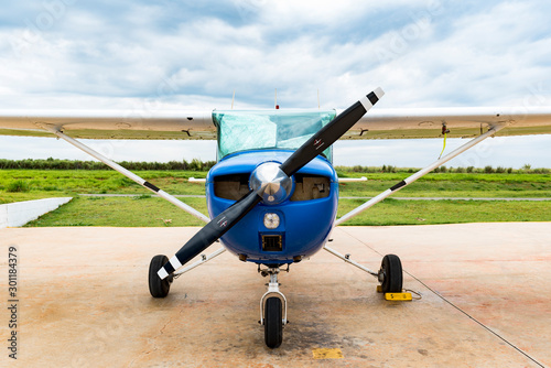 A blue single engine airplane or propeller aircraft on the ground