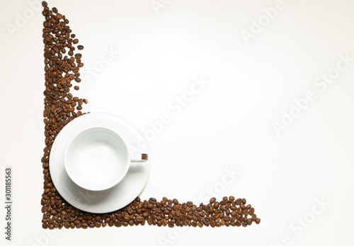 White cup with plate in coffee beans on the white background. Food or drink background photo with place for text.