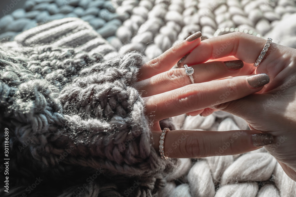  Close up of an elegant engagement diamond ring on woman finger with dark gray sweater winter clothe. love and wedding concept.soft and selective focus. - obrazy, fototapety, plakaty 