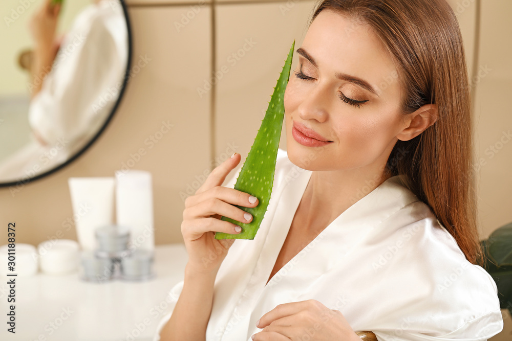 Beautiful young woman using aloe vera in bathroom Beautiful young woman using aloe vera in bathroom