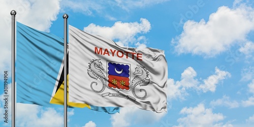 Saint Lucia and Mayotte flag waving in the wind against white cloudy blue sky together. Diplomacy concept, international relations.