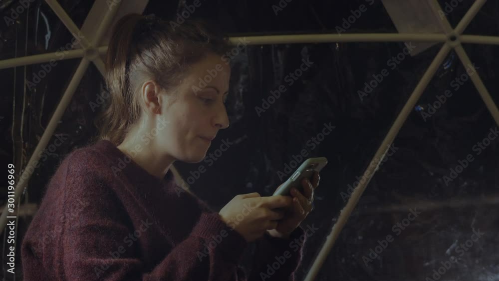 A woman browsing on her phone. HANDHELD.