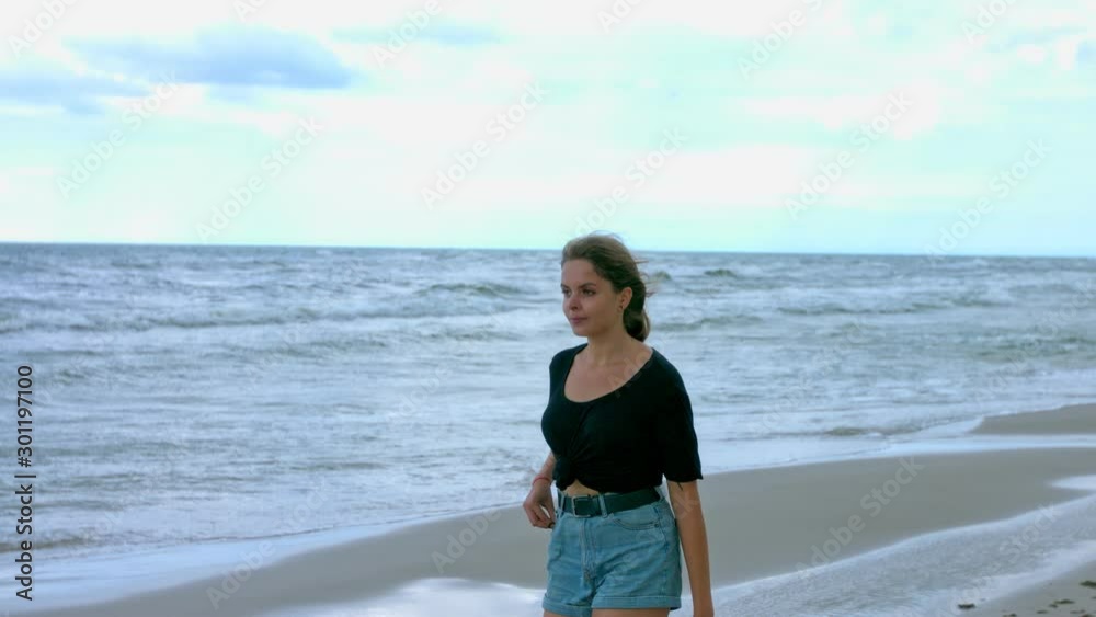 lady walking in wavy seaside, tracking medium shot lady walking in wavy seaside, tracking medium shot
