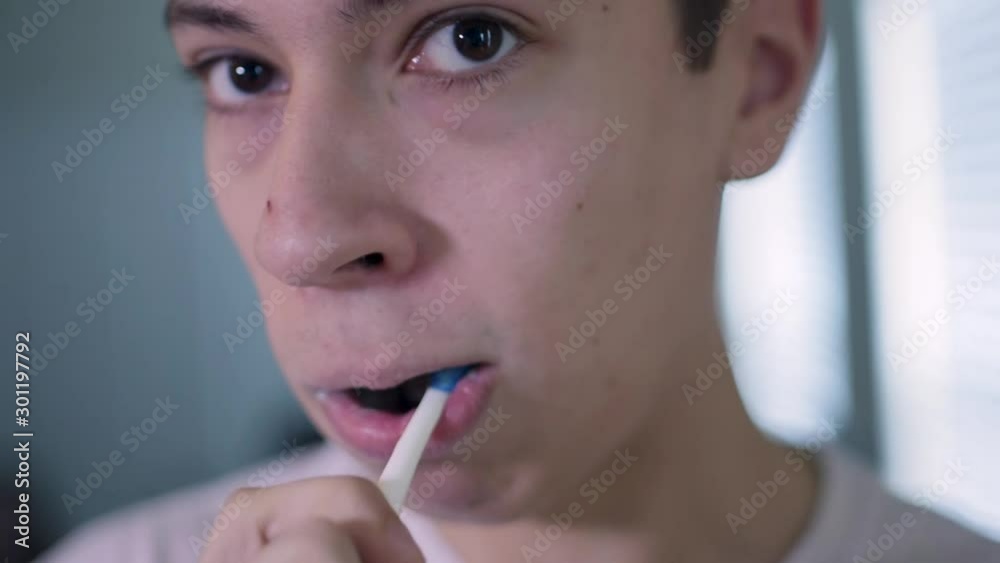 Young Caucasian Man Brushes Teeth Looking Straight at Camera Close Up Young Caucasian Man Brushes Teeth Looking Straight at Camera Close Up