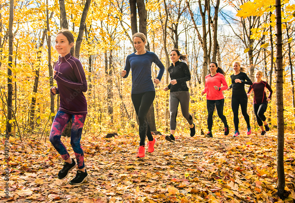 woman group out running together in an autumn park they run a race or train in a healthy outdoors lifestyle concept woman group out running together in an autumn park they run a race or train in a healthy outdoors lifestyle concept