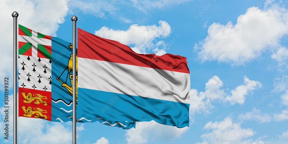 Saint Pierre And Miquelon and Luxembourg flag waving in the wind against white cloudy blue sky together. Diplomacy concept, international relations.