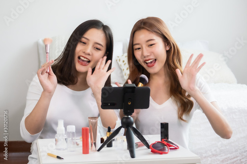 Portrait of young asian woman review giveaway gift product fan following channel, recording video make up lipstic cosmetic at home. Beauty blogger present beauty cosmetics photo