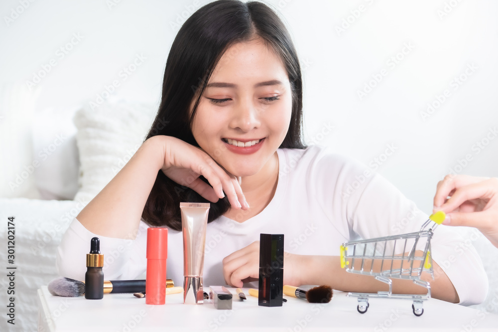 Asian woman shopping online for new dress. All content is made up.Model shopping cart, basket.Online shopping concept Asian woman shopping online for new dress. All content is made up.Model shopping cart, basket.Online shopping concept
