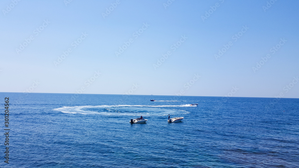Motor boats sail on the sea. Motor boats on the sea on a Sunny day. Water fun. Happy holiday at sea. Motor boats float in a circle. Motor boats sail on the sea. Motor boats on the sea on a Sunny day. Water fun. Happy holiday at sea. Motor boats float in a circle.