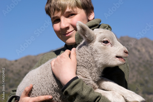 Joven en el campo cuidando a un amigo animal, su corderito.  photo