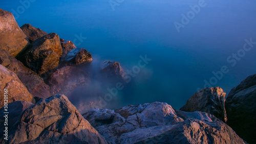Blue silky water in long exposure near the rocks, sea background. © LEO 78