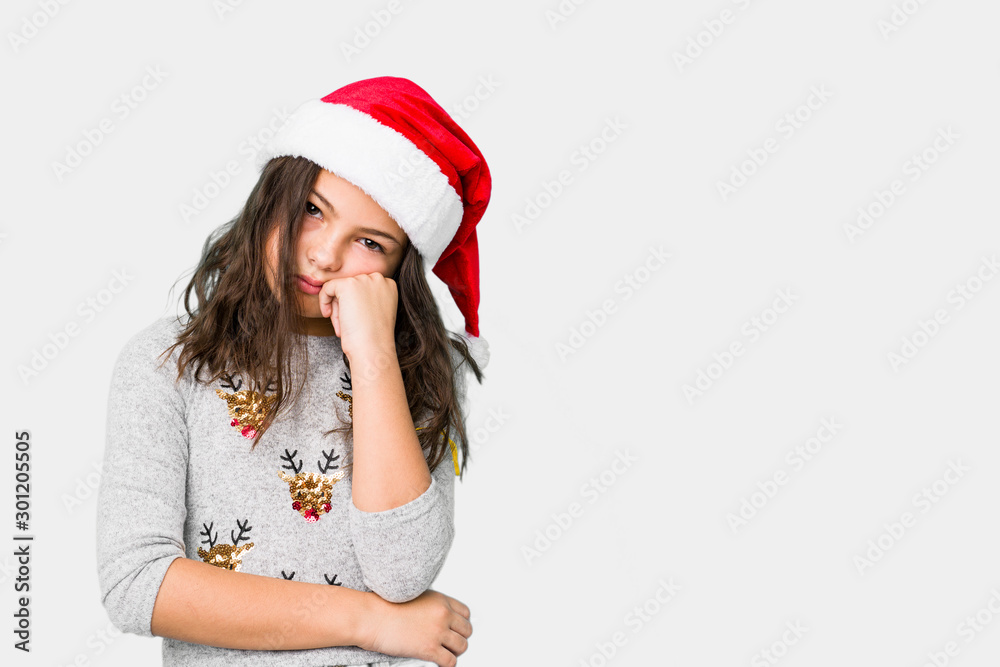 Little girl celebrating christmas day who feels sad and pensive, looking at copy space. Little girl celebrating christmas day who feels sad and pensive, looking at copy space.