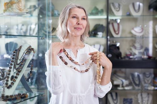 Cuadro en lienzo Woman trying on a gemstone necklace and earrings at a jewelry store