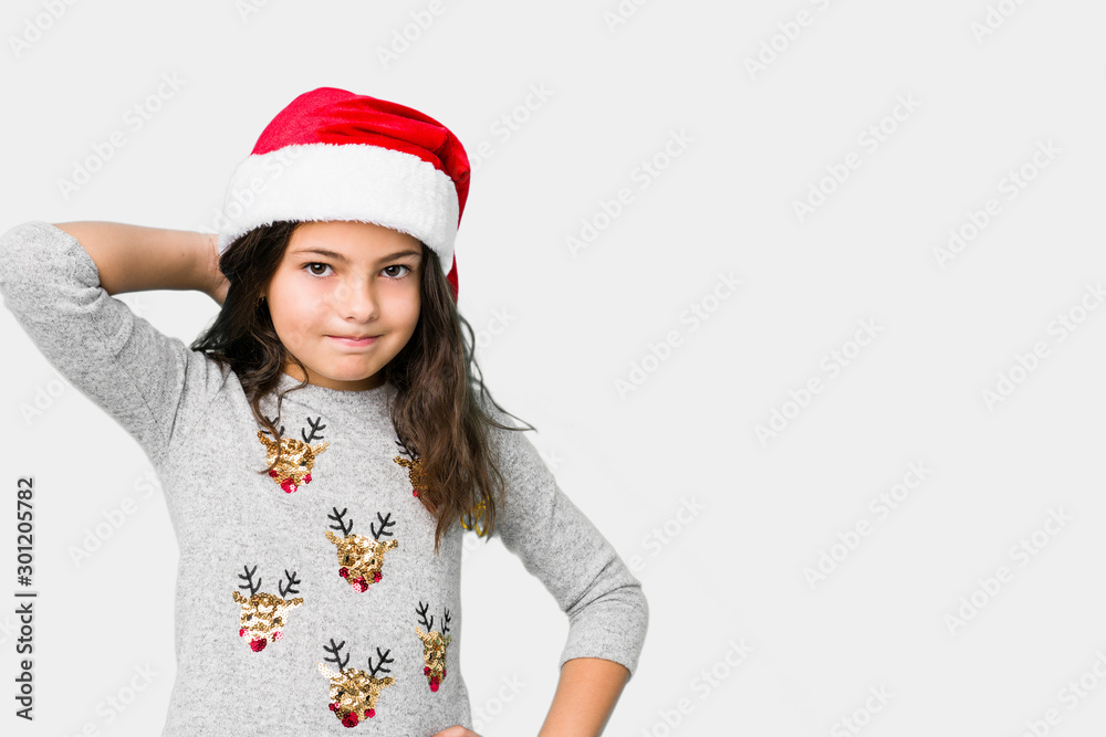 Little girl celebrating christmas day touching back of head, thinking and making a choice. Little girl celebrating christmas day touching back of head, thinking and making a choice.