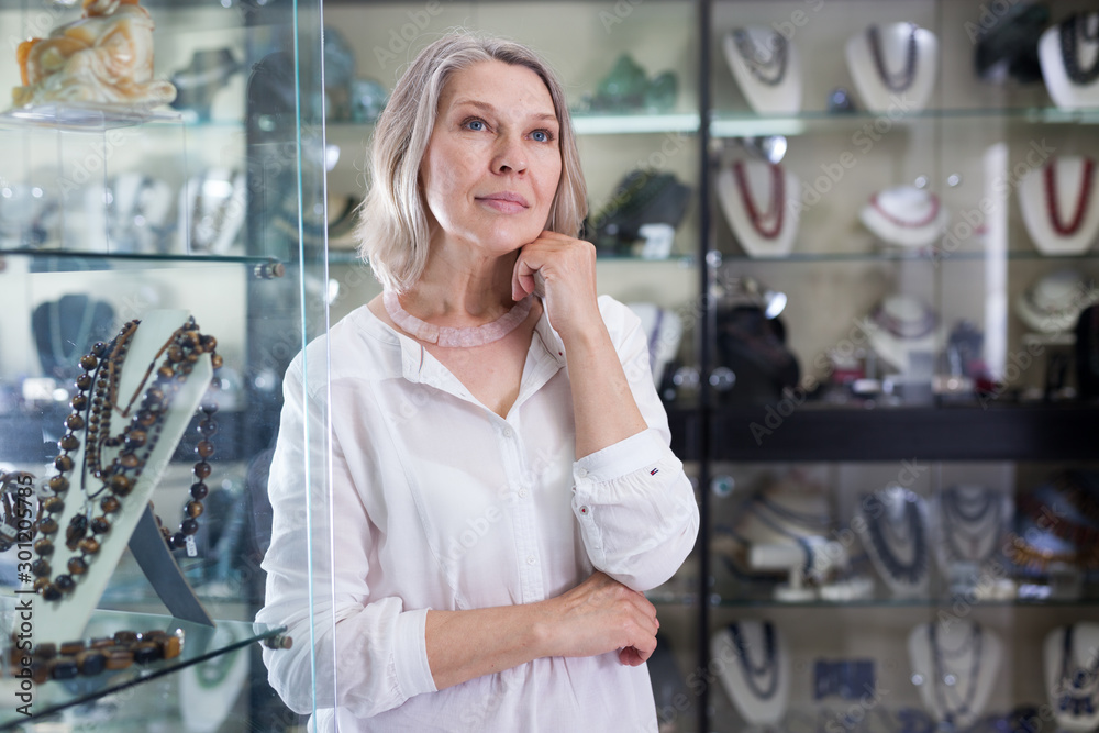 Woman chooses rose quartz jewelry in boutique