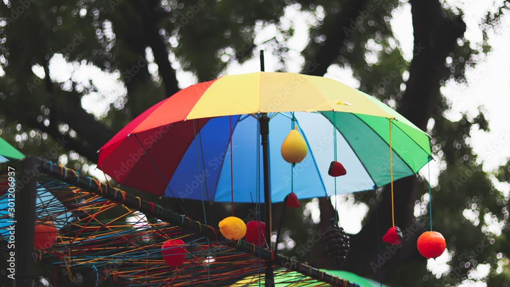 colorful umbrella in the park with colorful balls and bokeh tree