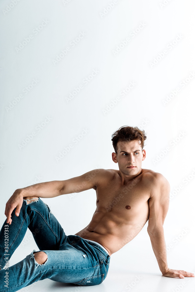 sexy young man in blue denim jeans sitting on white Stock Photo | Adobe  Stock
