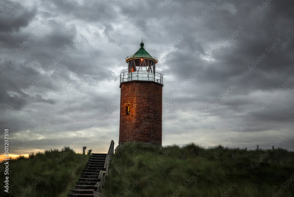 Brickstone lighthouse on high grass hills on Sylt at North Sea