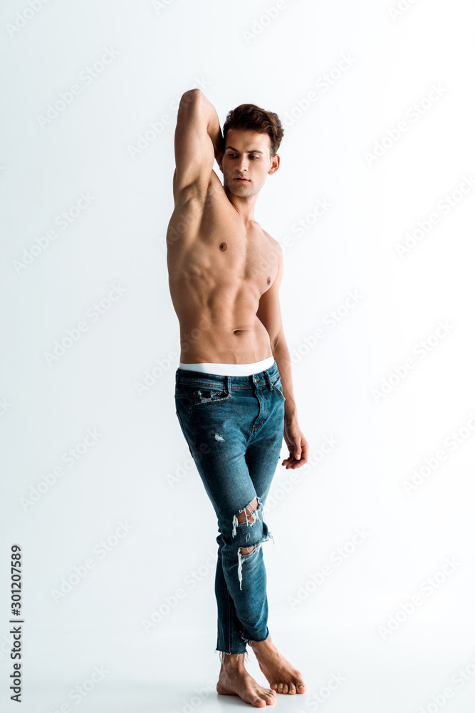 sexy man with barefoot standing in jeans on white sexy man with barefoot standing in jeans on white