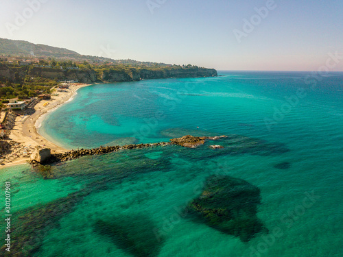 Aerial view of a paddle board in the water floating on a transparent sea  snorkeling. Bathers at sea. Tropea  Calabria  Italy. Diving relaxation and summer vacations. Italian coasts  beaches and rocks