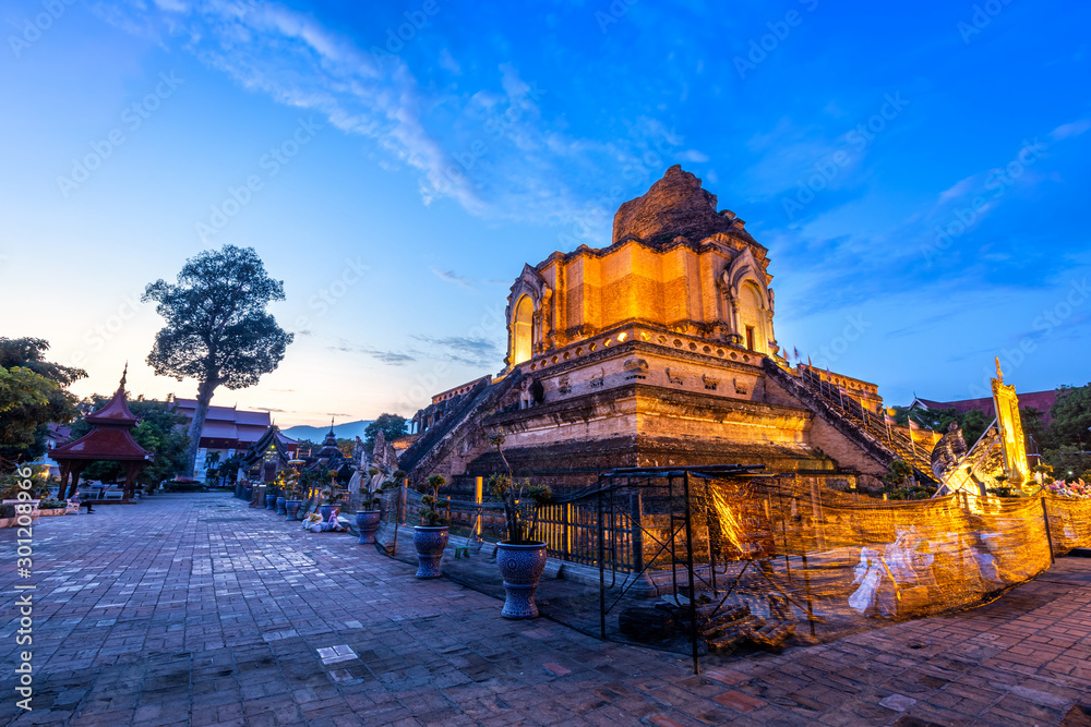 Fototapeta premium Wat Chedi Luang is a Buddhist temple in the historic centre and is a Buddhist temple is a major tourist attraction in Chiang Mai,Thailand.at twilight time blue sky clouds sunset background.