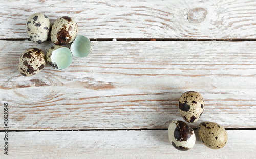 Quail eggs on a white wooden background background.