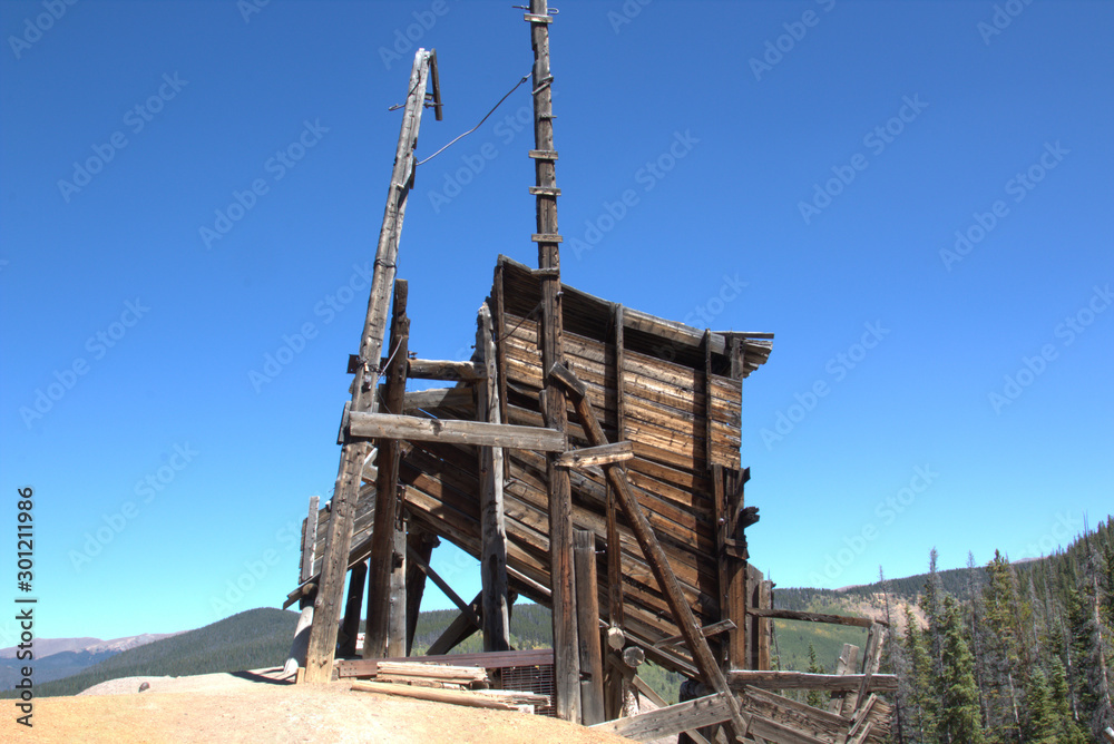 Headframes are wood structures constructed over a mine shaft or winze to support pulleys used with cables and hoists for haulage and access. Headframes are wood structures constructed over a mine shaft or winze to support pulleys used with cables and hoists for haulage and access.