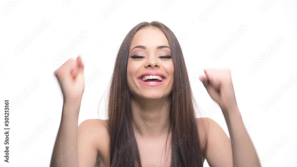 Excited cheerful young woman celebrating success smiling and shaking fists isolated on white background. Excited cheerful young woman celebrating success smiling and shaking fists isolated on white background.