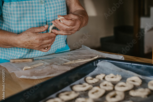 closeup of senior woman hands preparing candy or cakes