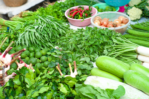 Closeup various types of fresh vegetables display in outdoor shop at morning flea market. photo