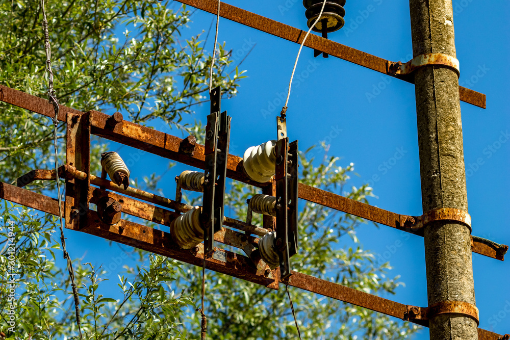Old rusty electric equipment with clear blue sky and green blurred forest background near the Blue Eye water source in Albania. Sunny spring day Old rusty electric equipment with clear blue sky and green blurred forest background near the Blue Eye water source in Albania. Sunny spring day