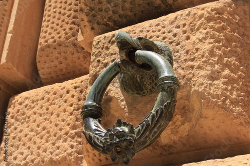 Bronze ring with an eagle head figure on the exterior wall of Charles V Palace at Alhambra Palace complex in Granada, Andalusia, Spain. photo