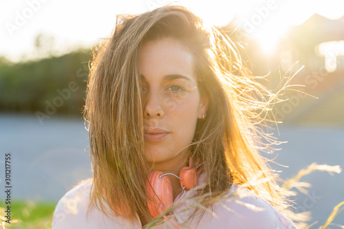 Portrait of young woman with blowing hair at backlight