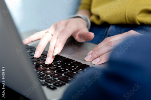Woman's hand typing on keyboard, close-up photo