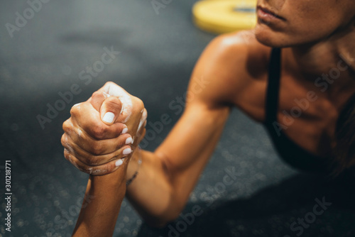 Two women in good shape doing arm wrestling challenge in a gym