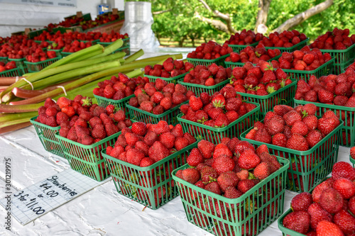 Fresh strawberries in the market are sold in plastic containers.