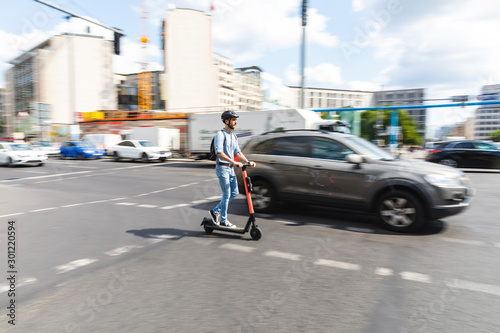 Wallpaper Mural Businessman riding e-scooter on the street in the city, Berlin, Germany Torontodigital.ca