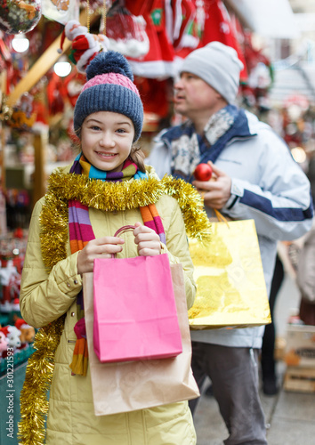 Smiling girl with father holding shopping bags