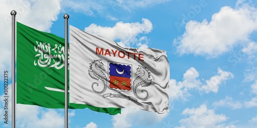 Saudi Arabia and Mayotte flag waving in the wind against white cloudy blue sky together. Diplomacy concept, international relations. photo