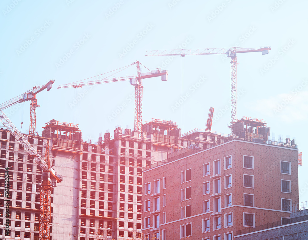 Multiple industrial cranes constructing buildings background