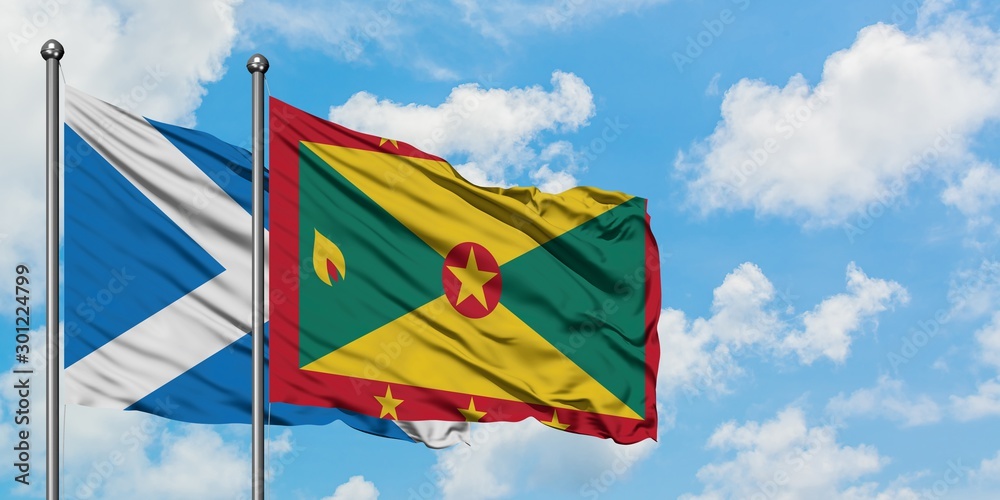 Scotland and Grenada flag waving in the wind against white cloudy blue sky together. Diplomacy concept, international relations. Scotland and Grenada flag waving in the wind against white cloudy blue sky together. Diplomacy concept, international relations.