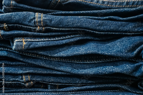 Stack of blue jeans trousers background