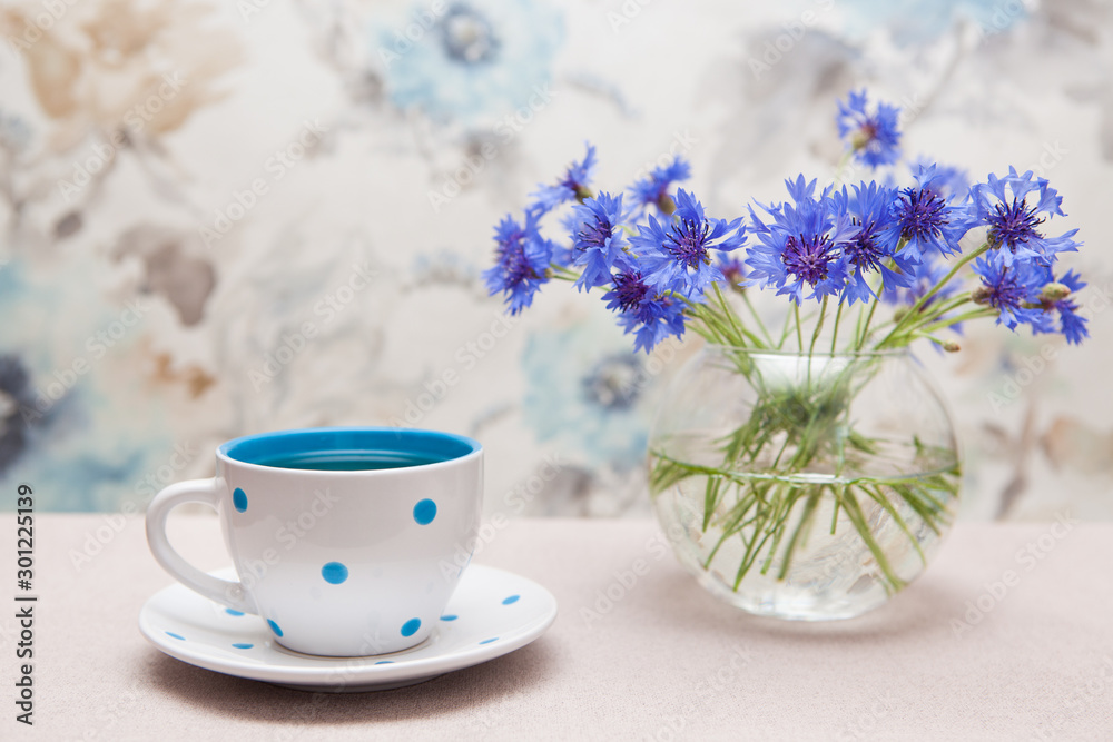 Tea in cup with dots and vase of cornflower flowers - card with still life Tea in cup with dots and vase of cornflower flowers - card with still life
