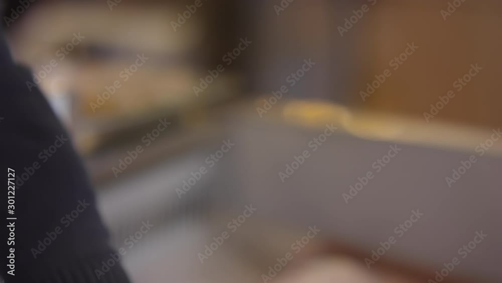 Close up shot of hands of salesman in disposable gloves showing gills of fresh fish to customers while selling seafood in store Close up shot of hands of salesman in disposable gloves showing gills of fresh fish to customers while selling seafood in store